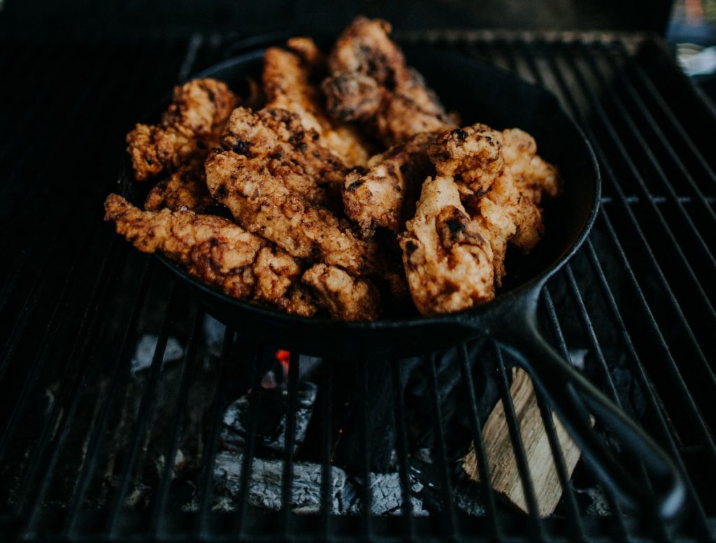 A cast iron pan with chicken inside.