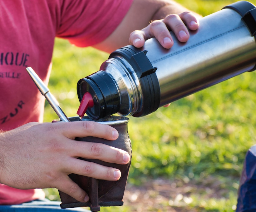 Man holding mug and pouring thermos