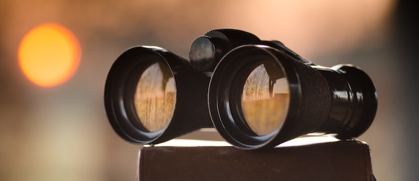 Black binoculars with sun in background