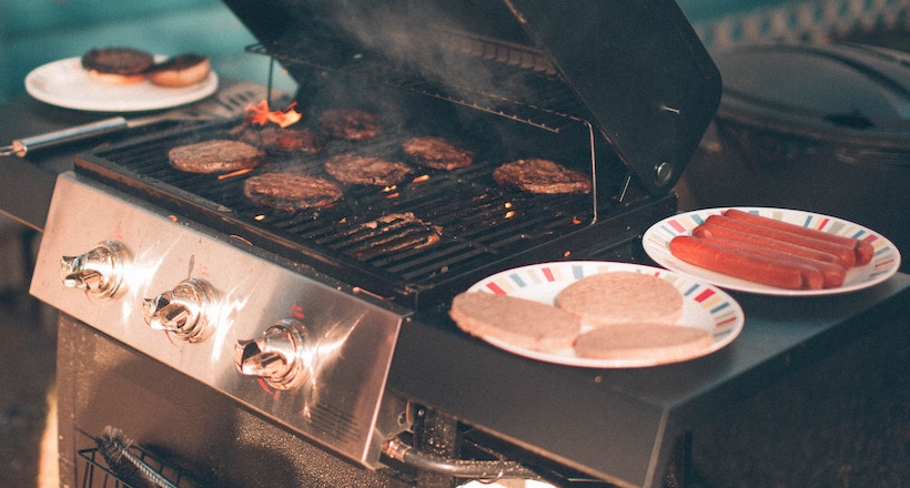 Burgers on the grill plus other foods ready to grill