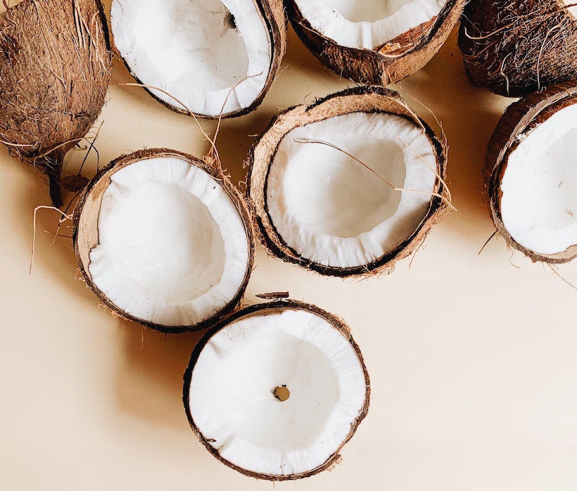 A few coconut husks split in two showing meat inside