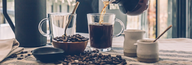 Pour coffee from carafe to glass cup