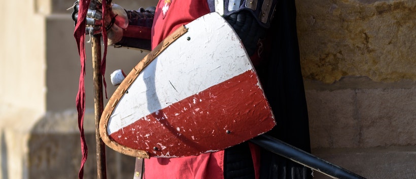 Soldier holding a red and white/grey shield