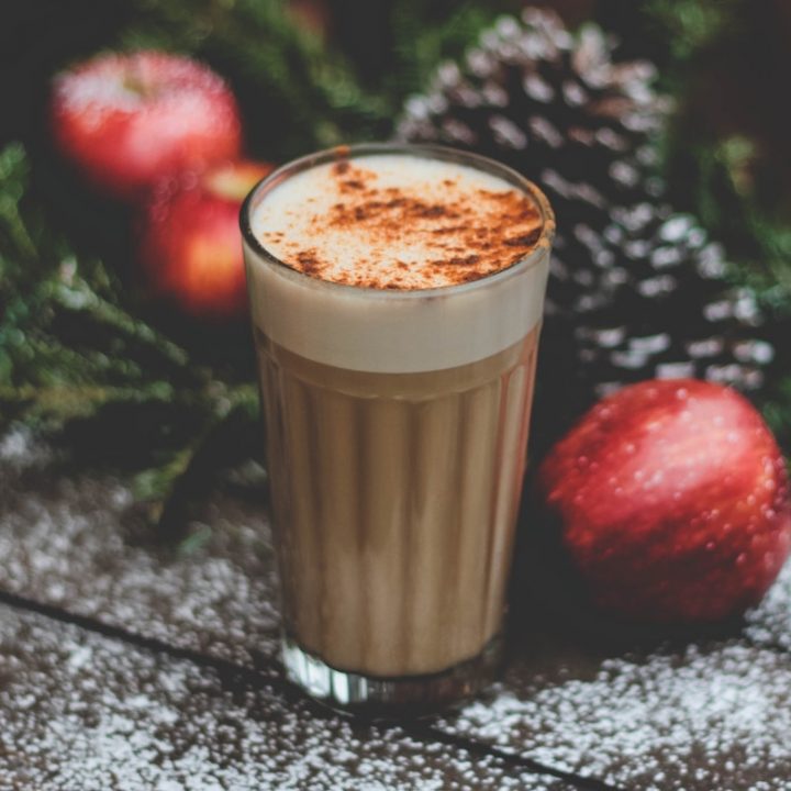 Eggnog with spices in a cup near Christmas decorations