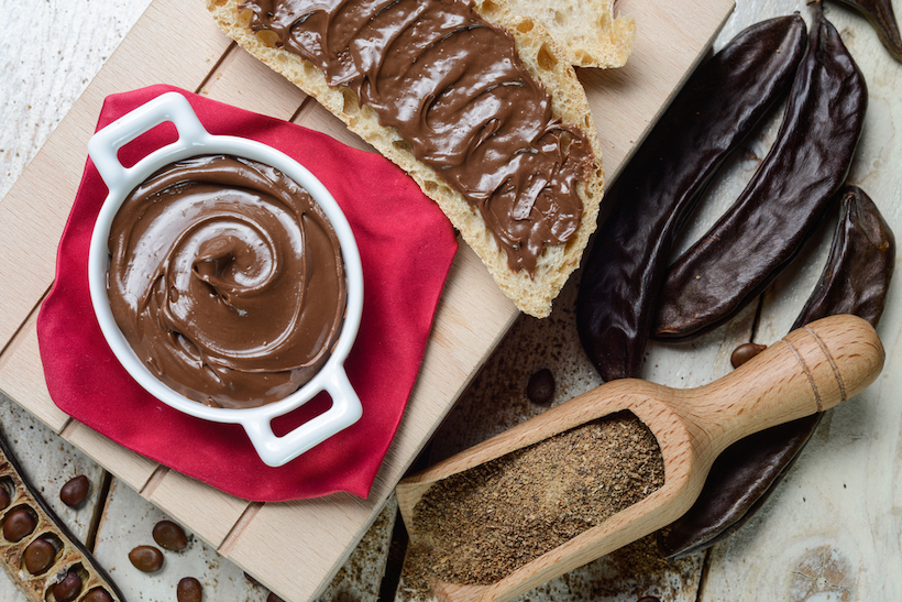 Top view of carob cream, pods, and powder