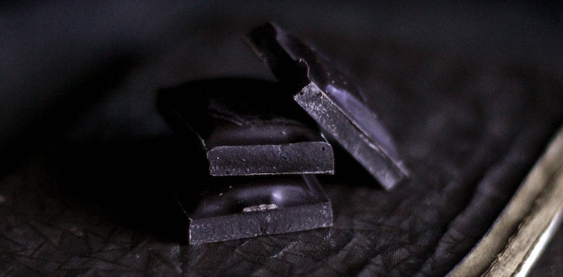 Dark chocolate squares stacked on a table