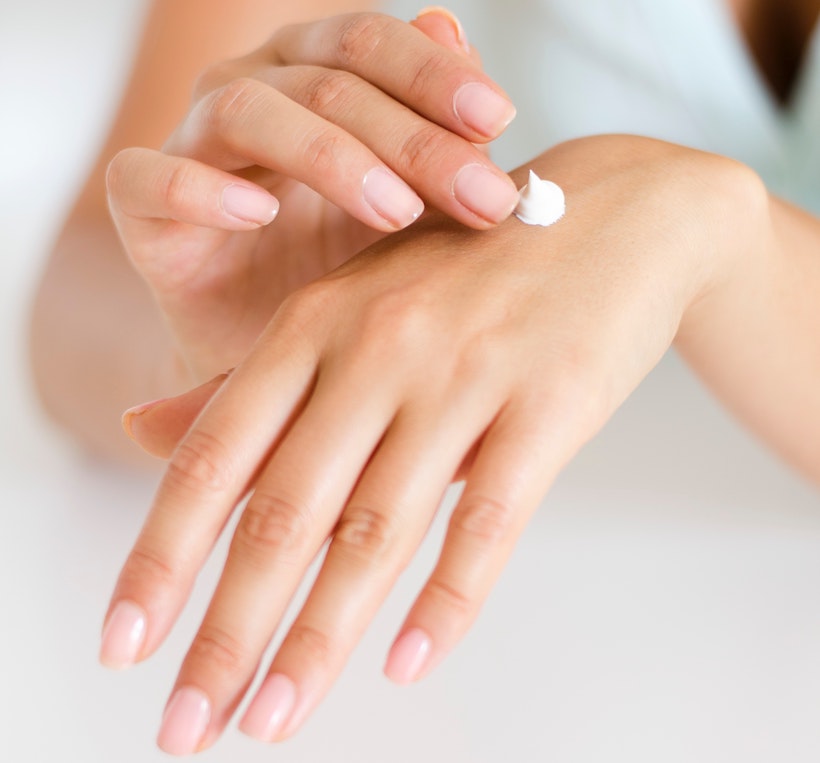 Lady applying lotion to rub into her hands