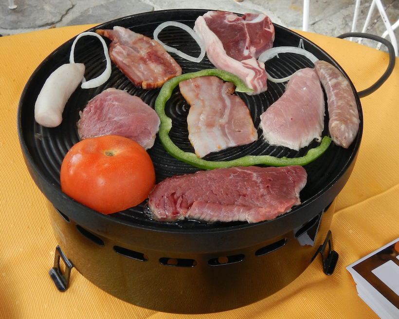 Round raclette grill with meat and vegetables