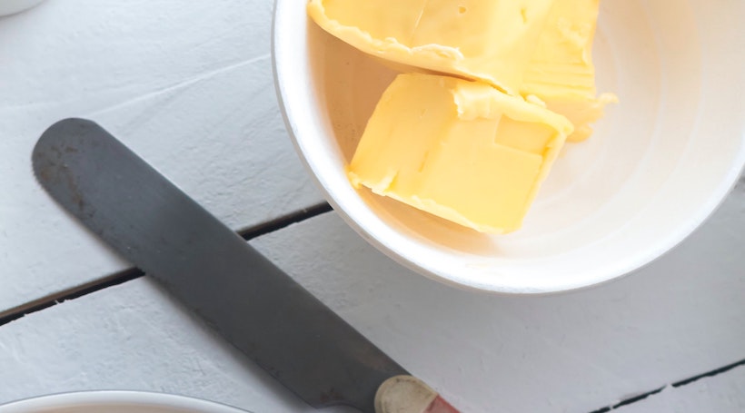 Butter knife next to a dish with butter