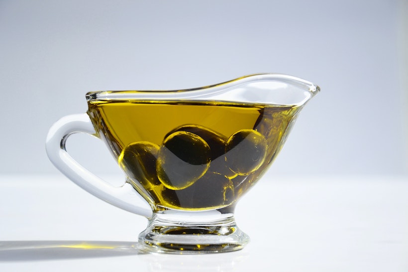 Pitcher with olive oil and olives inside