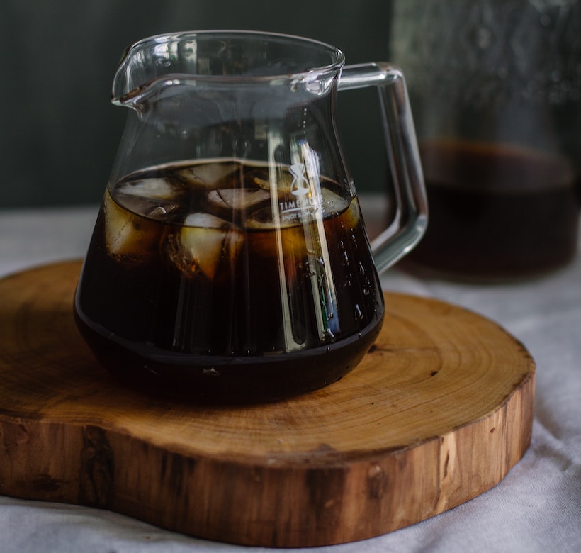 Glass pitcher with ice and coffee