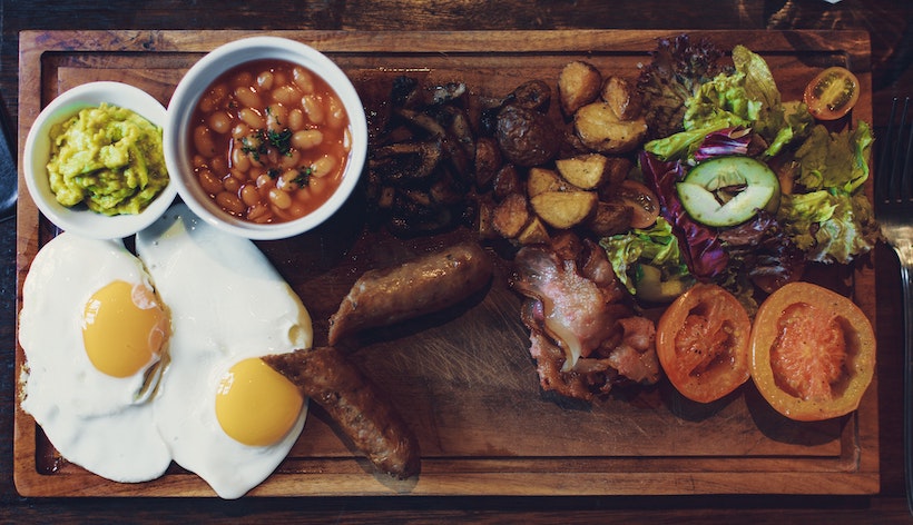 Eggs, beans, tomatoes, potatoes, and salads on wood