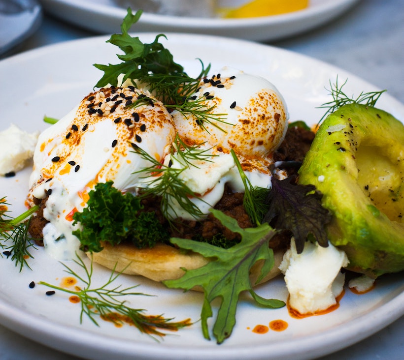 Soft boiled eggs on top of bread with avocado