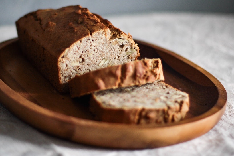 Sliced dark whole grain bread on a wooden plate