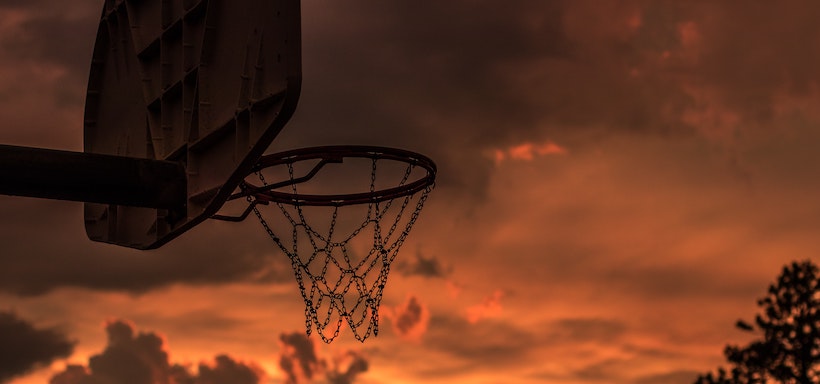 Ominous orange sky behind basketball hoop