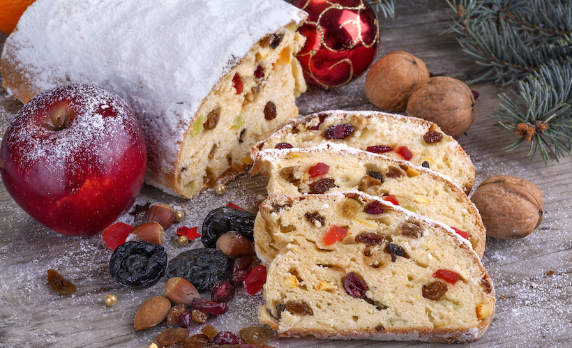 Stollen like fruitcake cut open with powdered sugar and dried fruit